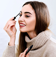 Modelka w beżowym golfie stosująca odżywkę do brwi Nanobrow