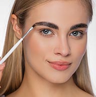 Modelka używająca szczoteki do laminowania brwi