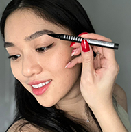 Azjatycka modelka używająca pióra microblading na brwiach