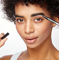 Czarna kobieta z kręconymi włosami i jedną brwią grubszą dzięki pisakowi Microblading Pen