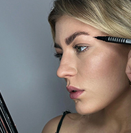 Profil boczny blond modelki przykładającej pióro