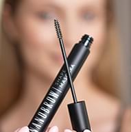 Modelka w tle, w centrum uwagi jest Shape Mascara, tworząca za pomocą szczoteczki kształt X