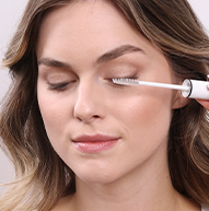 Modelka brunetka z zamkniętymi oczami używa podkładu